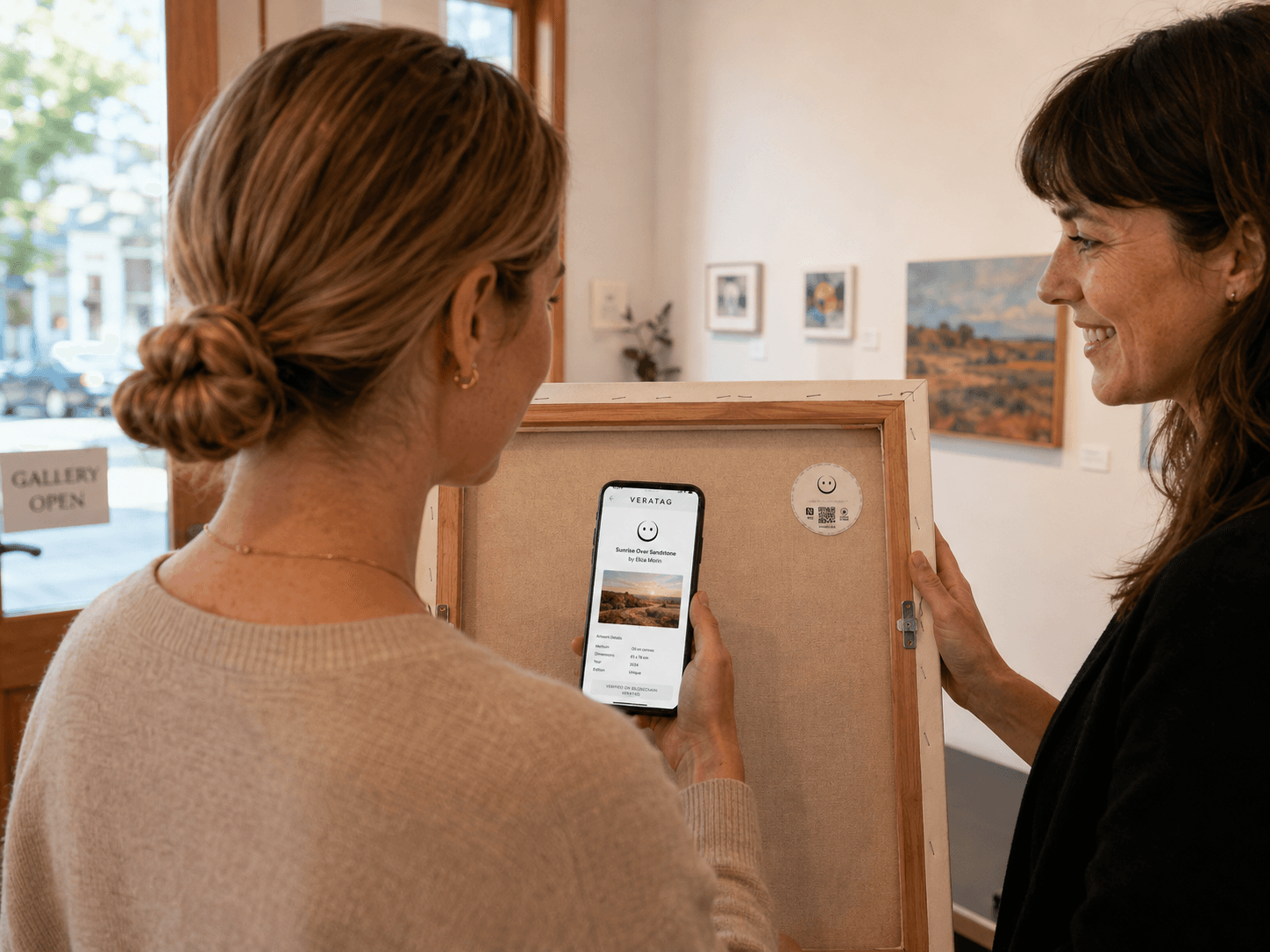 A collector and gallery professional reviewing a tagged artwork and its passport